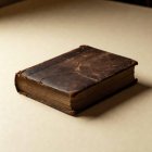A closed antique book on a cream ground