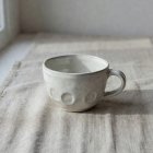 A ceramic teacup on a plain linen cloth